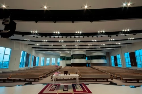 Auditório do colégio visto do palco com iluminação e sistema de som