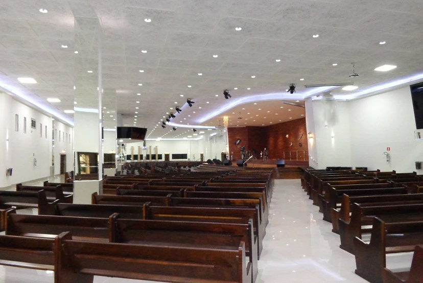 Banco em salão principal de Igreja bem iluminada e largo corredor