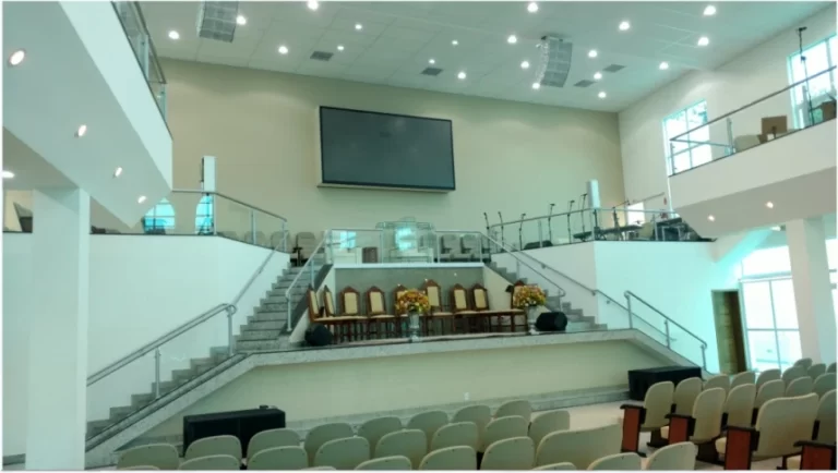 Púlpito de uma igreja com televisão acima e equipamentos musicais