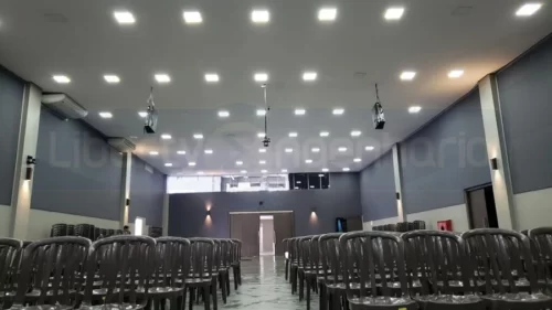 Cadeiras de plástico em salão principal de Igreja bem iluminada